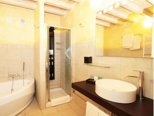 VignaleVilla Morneto的浴室配有水槽、淋浴和浴缸。