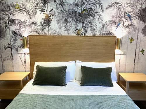 布尔戈斯Emérita Luxury Home的一张带两个枕头的床和花卉壁纸
