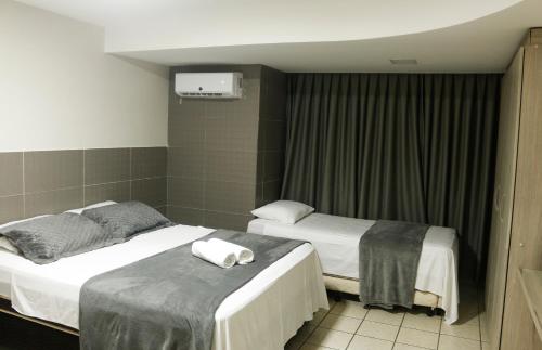 纳塔尔Atlântico Flat Natal的两张位于酒店客房的床,配有毛巾