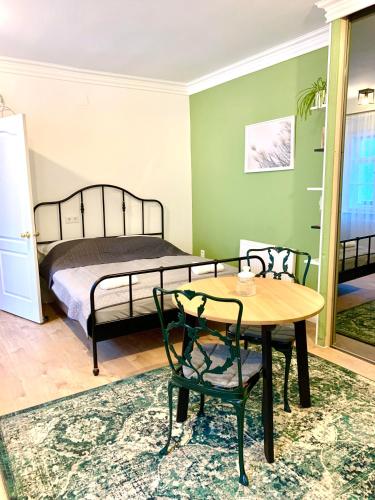 索普隆Fidelissima Apartman的卧室配有一张床和一张桌子及椅子