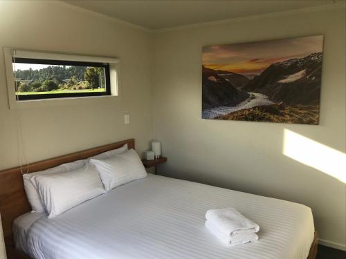 弗朗兹约瑟夫Alpine Escape的一间卧室配有一张带白色床单的床和一扇窗户。