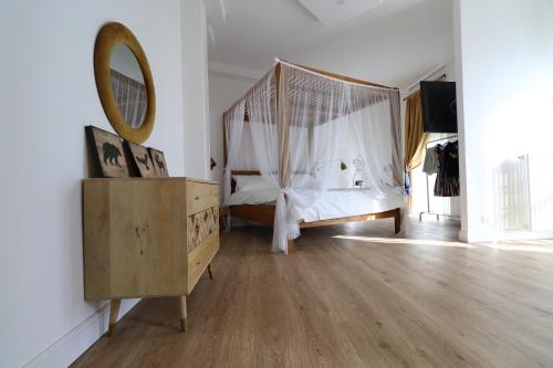 都灵Baby Hotel的一间卧室配有天蓬床和镜子