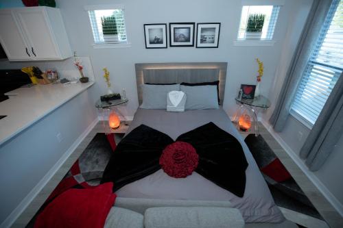 奥兰多Pet Friendly Modern Zen Studio Retreat with Hot Tub! home的一间卧室配有一张床、一张沙发和两个窗户。
