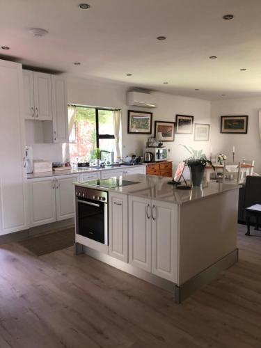 约翰内斯堡Waybury Cottage - a cozy home from home !的厨房配有白色橱柜和炉灶烤箱。