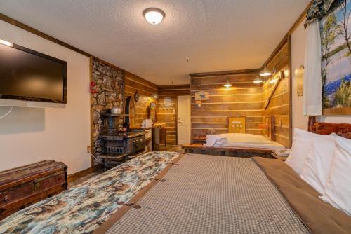 BrewerVacationland Inn & Suites的一间卧室配有一张床,并在一间客房内配有电视。