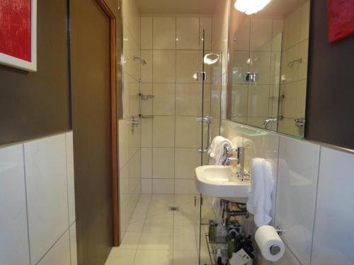 Portobello伊迪山船长酒店的一间带水槽和玻璃门淋浴的浴室