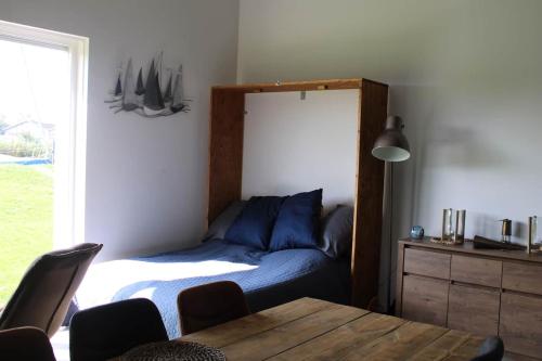 赫劳BakBoord的一间卧室配有一张床、一张桌子和一个窗户。