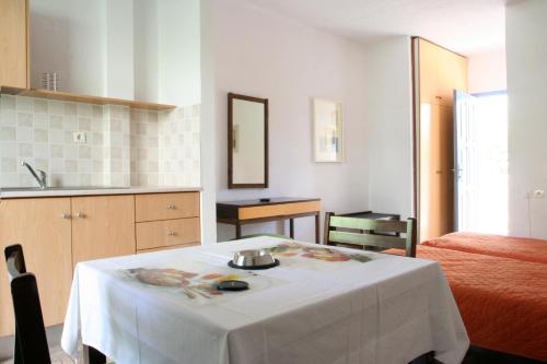 科斯镇伊斯伯利斯公寓式酒店的厨房配有带白色桌布的桌子