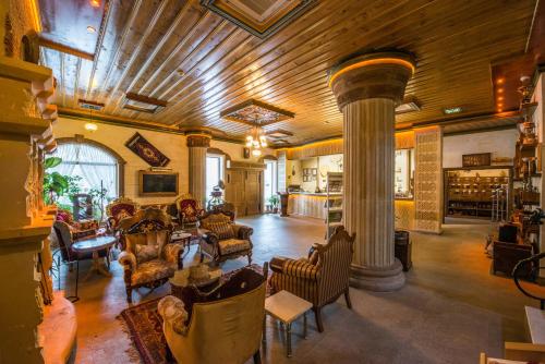 内夫谢希尔Kapadokya Hill Hotel & Spa (12+)的一个带柱子和椅子的大客厅