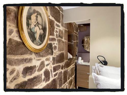 圣让皮耶德波尔易博尔纳特住宿加早餐旅馆的卧室里石墙上的一幅画