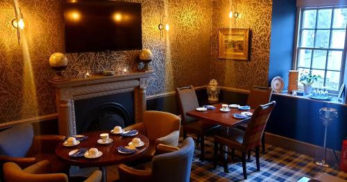 斯佩河畔格兰敦庭院酒店的一间带2张桌子和壁炉的用餐室