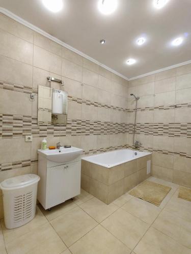 敖德萨Уютная квартира с панорамой города的带浴缸、盥洗盆和卫生间的浴室