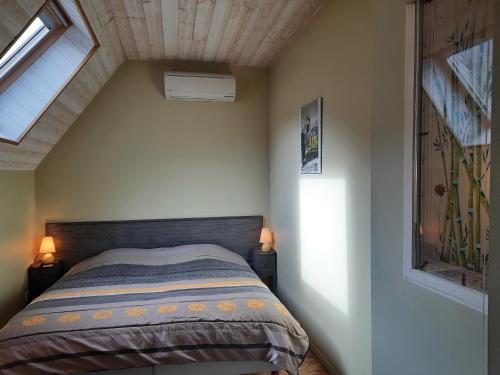 LortetGîte de la Grenouille - 5-7 places - vallée d'Aure的一间卧室配有一张带两盏灯的床和一扇窗户。