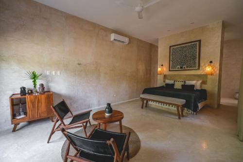 图卢姆Wakax Hacienda - Cenote & Boutique Hotel的卧室配有一张床和一张桌子及椅子