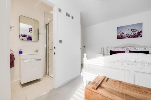 林德赫斯特Spire View - New Forest Holiday Home的白色的浴室设有一张大床和镜子