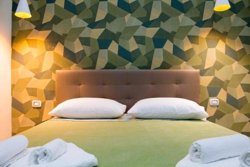 那不勒斯WANDERLUST NAPLES a place to stay的一张带两个枕头的床和彩色的墙壁