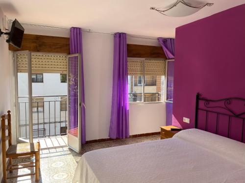 里奥帕尔Hostal Grimaldos的紫色卧室配有一张床和一个阳台
