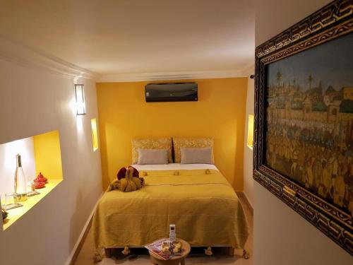 马拉喀什Riad BILKIS的卧室配有一张床,墙上挂有绘画作品