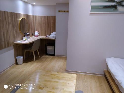 罗东镇米淇旅店 - 罗东馆 的客房设有一张床和一张带镜子的书桌