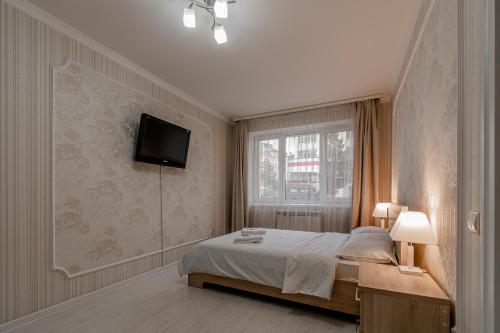切博克萨雷Apartment on Ivana Franko 7的卧室配有一张床,墙上配有电视。