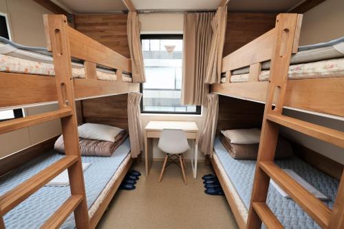 东京Tokyo Ueno Youth Hostel的宿舍间配有双层床和书桌。