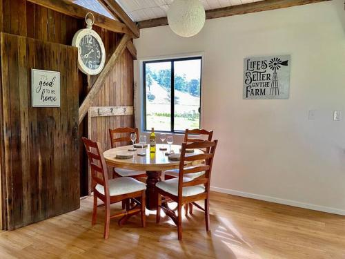 KenilworthStay at the Barn... Immerse yourself in nature.的一间带桌椅和时钟的用餐室