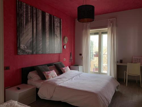 罗马Stileroma的卧室设有红色的墙壁和一张带白色床单的床