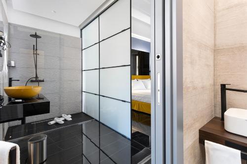 那不勒斯Hotel Poerio 25 Boutique Stay的浴室设有玻璃隔板、水槽和床