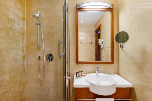 布达佩斯Hotel Bristol Budapest的浴室配有盥洗盆和带镜子的淋浴