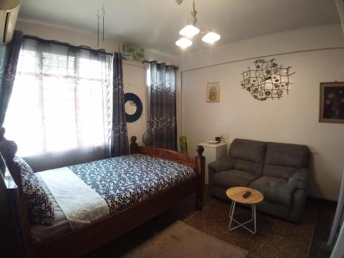 蒙巴萨RAFIKI Apartment的一间卧室配有一张床、一张沙发和一把椅子