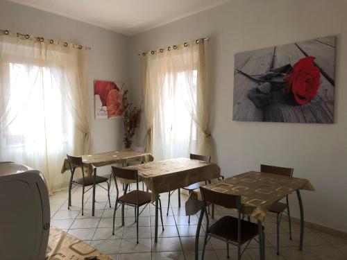维博瓦伦蒂亚玫扎住宿加早餐旅馆的一间用餐室,配有两张桌子和椅子,还有一幅画
