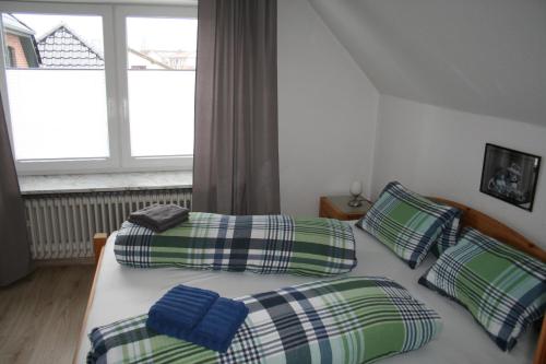 EggebekFerienhaus Frey的一间卧室设有两张单人床和一个窗户。