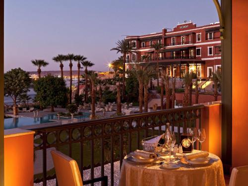 阿斯旺老卡塔拉特索菲特尔传奇酒店的享有度假胜地景致的阳台上的桌子