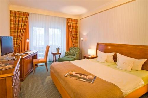 肖林慕勒豪斯海景酒店的酒店客房配有一张床、一张书桌和一台电视。