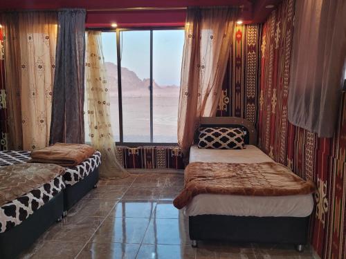 瓦迪拉姆Shakria Bedouin Life Camp的一间设有两张床的卧室,享有沙漠美景