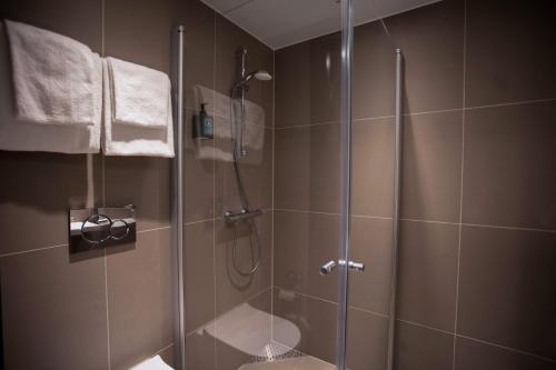 波多Comfort Hotel Bodø的带淋浴的浴室和玻璃门