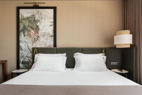 波尔图Exe Essenzia Porto的卧室配有带白色枕头的大床