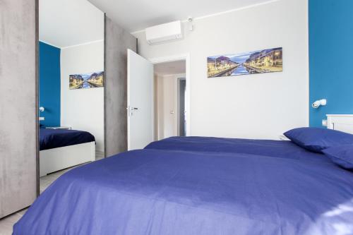 米兰DADA 2bd App - nuovo in CENTRO zona Navigli的一间卧室配有蓝色的床和镜子