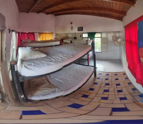 塔甘加hostal alquimista的铺有瓷砖地板的客房配有两张双层床。