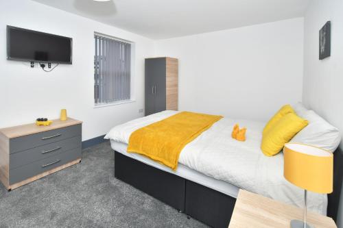 EtruriaTownhouse @ 24 Brunswick Place Stoke的一间卧室配有一张带黄色毯子的大床