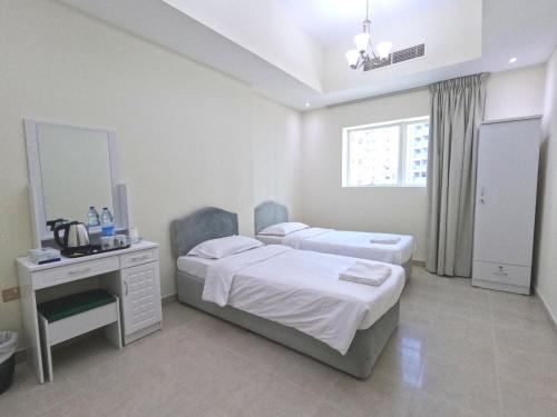 迪拜Barsha Star Residence - Home Stay的一间卧室配有两张床、一张桌子和一面镜子