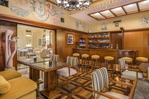 里斯本Hotel Britania Art Deco - Lisbon Heritage Collection - Avenida的餐厅设有酒吧,配有桌椅