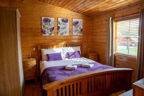 KettlebridgeThe Steadings Log Cabins的小木屋内一间卧室,配有一张床