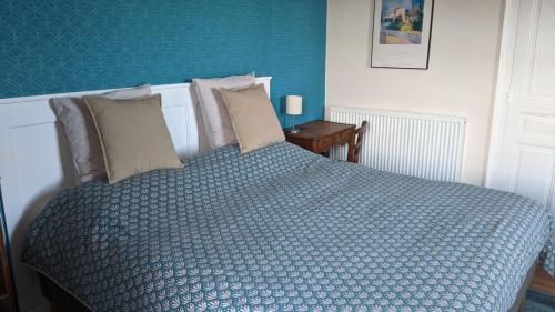 Saint-Cirgues-de-JordanneLa Maison Normande的一间卧室配有一张带蓝色床单和枕头的床。