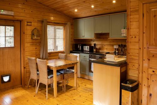 KettlebridgeThe Steadings Log Cabins的小屋内的厨房配有桌椅