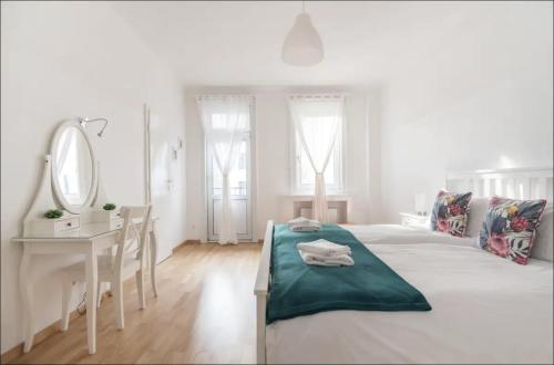 维也纳Operastreet City Center Apartment Brasil的白色卧室配有床、书桌和镜子