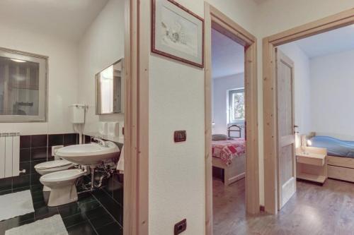 博尔米奥Residence La Contea的一间带水槽和卫生间的浴室以及一张床