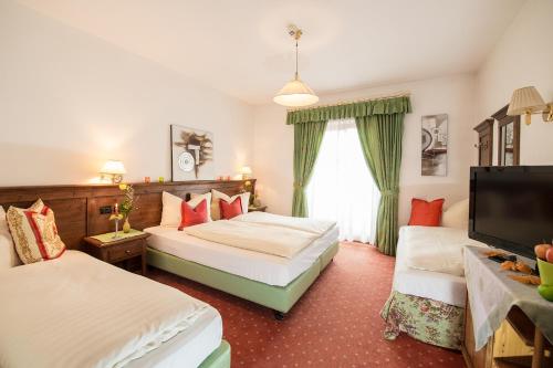 纳兹-夏韦斯Hotel Restaurant Putzer的酒店客房设有两张床和一台平面电视。