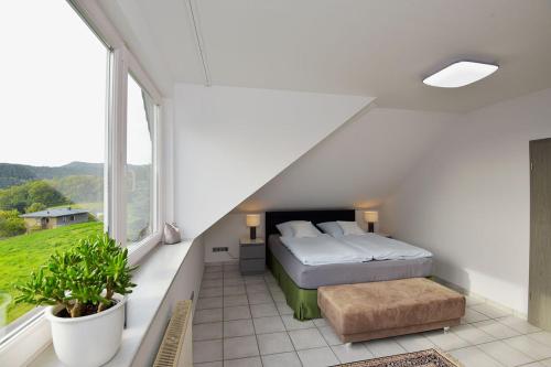 鲁多尔施塔特Studioappartment SAALEBLICK的一间卧室设有一张床和一个大窗户