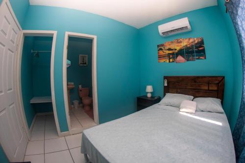 西区Bliss on the Bay的一间蓝色的卧室,配有一张床和一间浴室